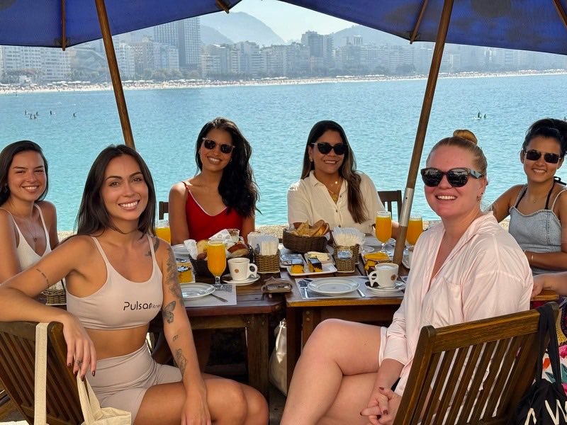 Mulheres da comunidade reunidas em um café da manhã à beira-mar, em Copacabana.